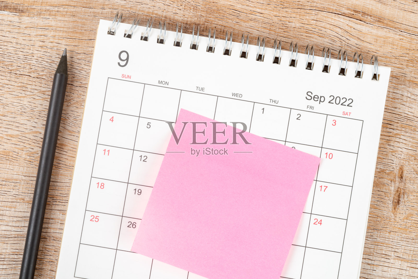 铅笔的顶部视图，日历计划和最后期限贴在木制背景上，日历桌2022年9月照片摄影图片