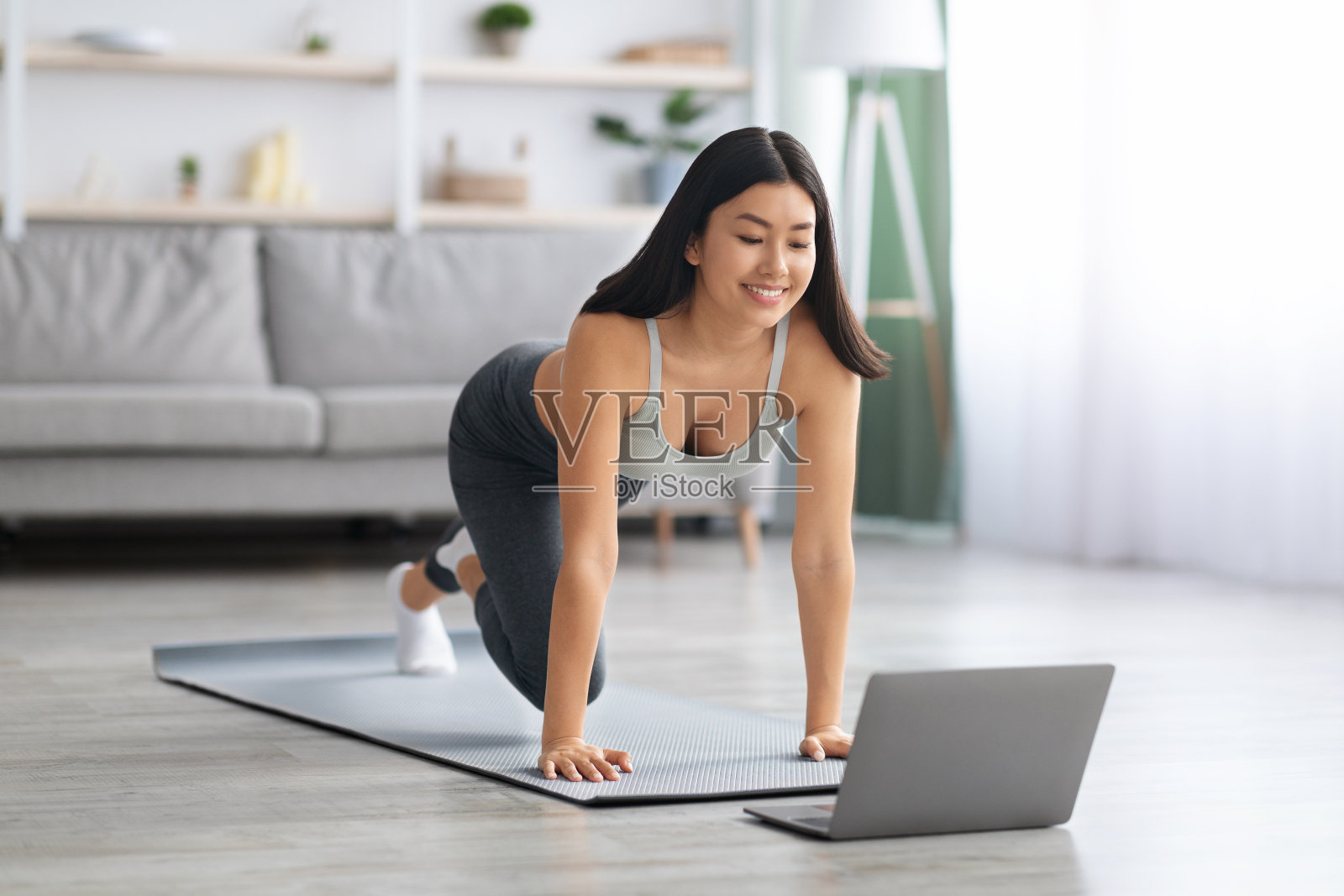 快乐健身亚洲女士制作在线体育训练在家里与笔记本电脑照片摄影图片