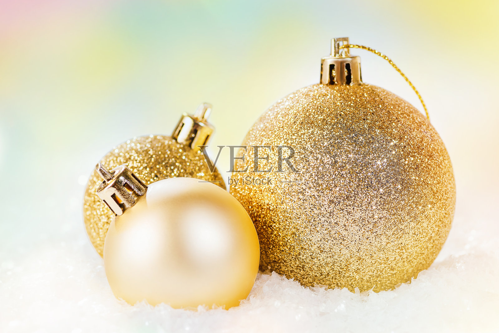各种金光闪闪的圣诞球在雪地上以浅色为背景。圣诞和新年亮片，闪亮的背景。圣诞节,冬天,新年的概念。家居装饰。新年的装饰品。照片摄影图片