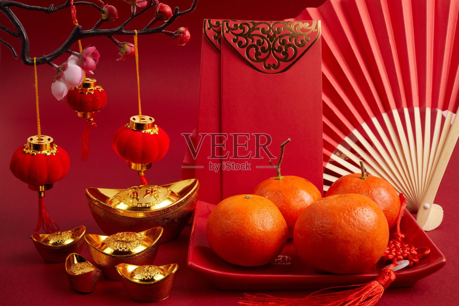 中国新年节日的装饰品。橙色，红包，梅花和压岁钱。翻译:让万个愿望成真。照片摄影图片