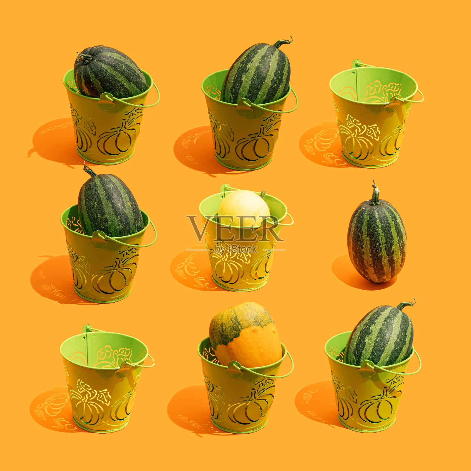 创意秋季想法南瓜装饰绿色桶在橙色的背景。唯美的感恩节或万圣节组成极简风格，潮流的颜色。照片摄影图片