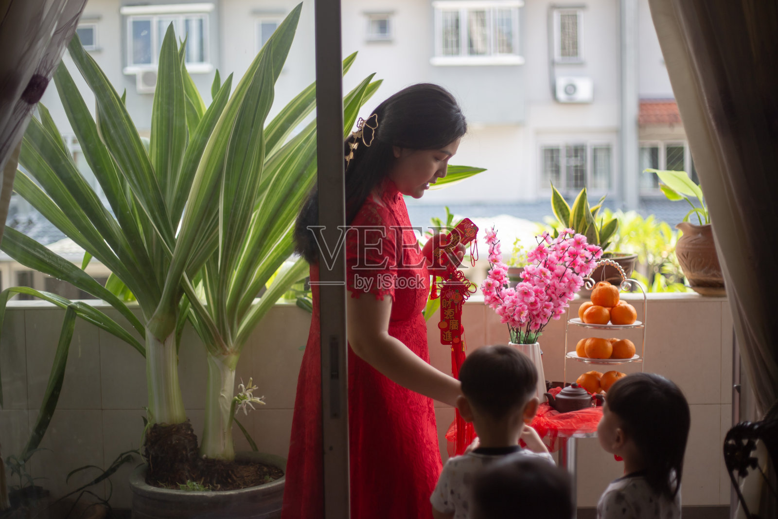 亚洲华人妇女和孩子们为中国新年装饰他们的房子照片摄影图片
