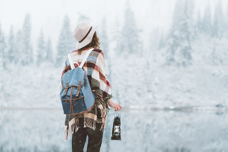 年轻的女旅人拿着油灯在野外享受初雪图片下载